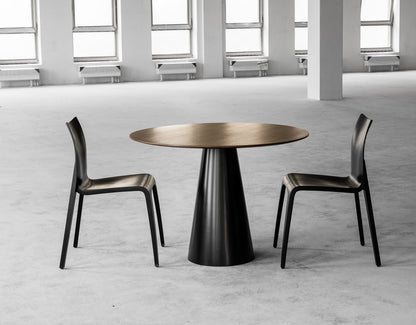 Zwei Esszimmerstühle FLOW in Schwarz an einem runden Tisch im Loft