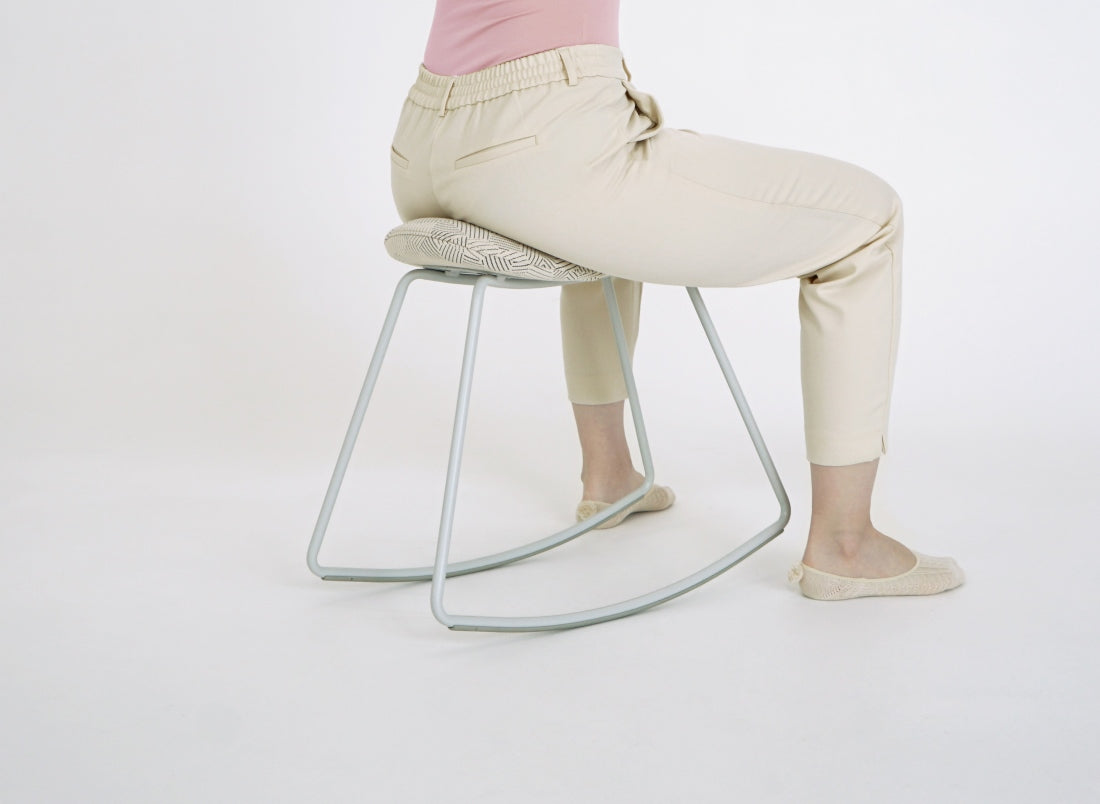 Sattelposition auf dem ergonomischen Bürohocker JOJIKO in skandinavischem Stil mit weißem Metallgestell und Stoffbezug mit Mustern