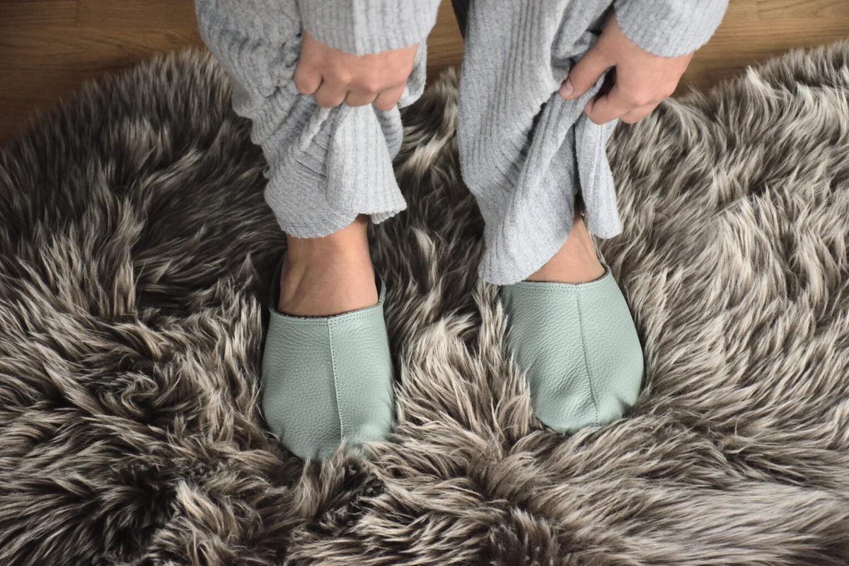 Sulbi Slippers aus recyceltem Leder in der Farbe Mint auf braunem Flauschteppich von der estnischen Firma OmaKing