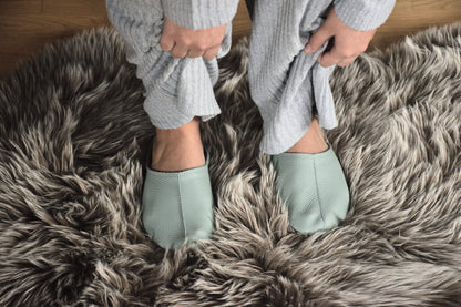 Sulbi Slippers aus recyceltem Leder in der Farbe Mint auf braunem Flauschteppich von der estnischen Firma OmaKing