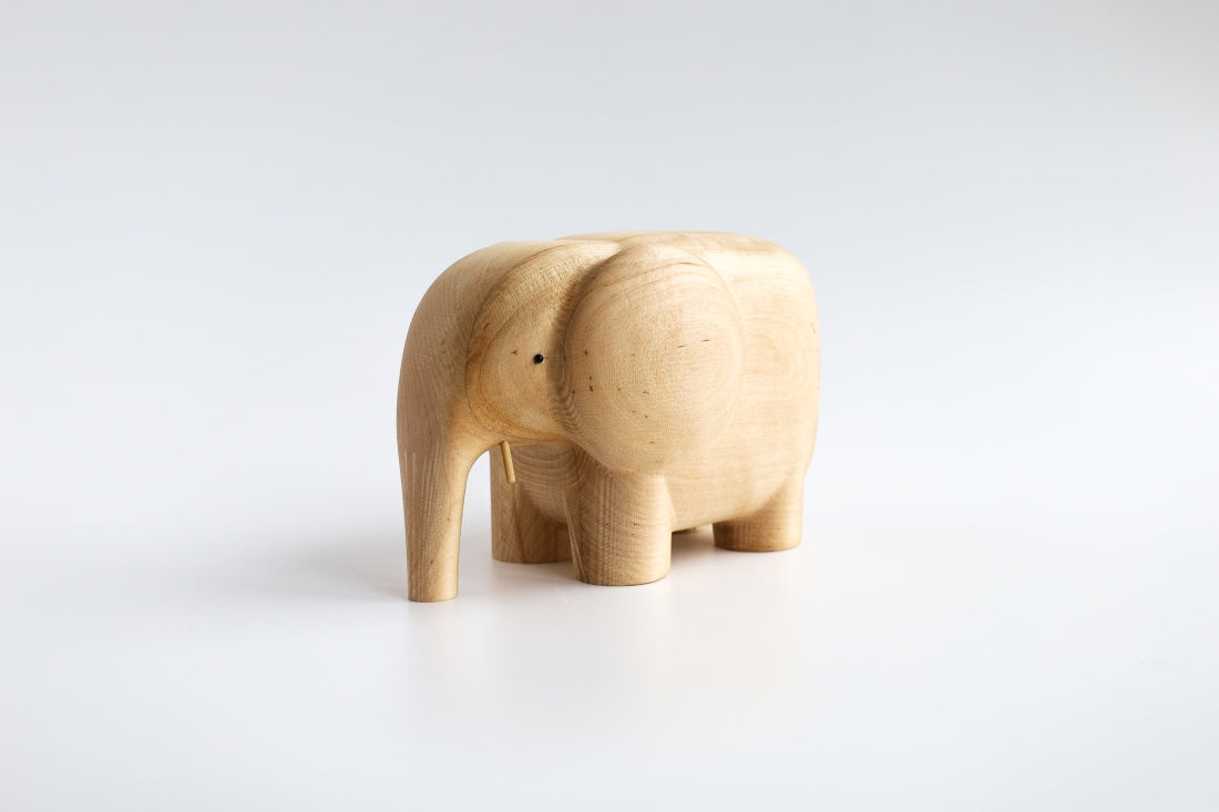 Holzfigur ELEFANT aus hellem Hartholz schräg von vorne aufgenommen aus der "I Piccolini"-Kollektion. Hersteller: Emko (Vilnius)