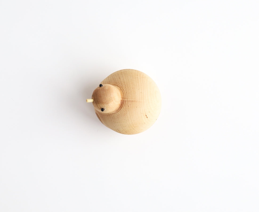Holzfigur BRÜTENDER VOGEL aus hellem Hartholz von oben aufgenommen aus der "I Piccolini"-Kollektion. Hersteller: Emko (Vilnius)