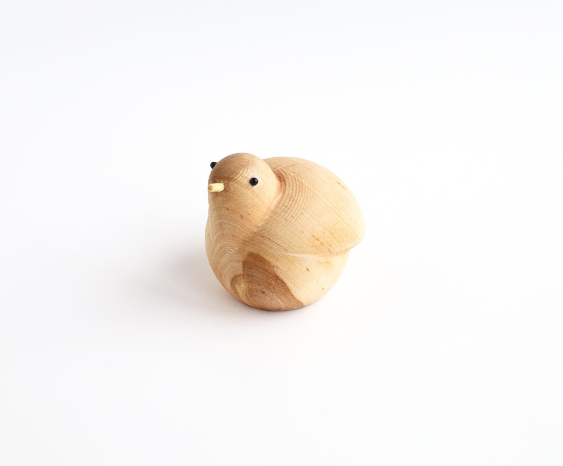 Holzfigur BRÜTENDER VOGEL aus hellem Hartholz schräg von vorne aufgenommen aus der "I Piccolini"-Kollektion. Hersteller: Emko (Vilnius)