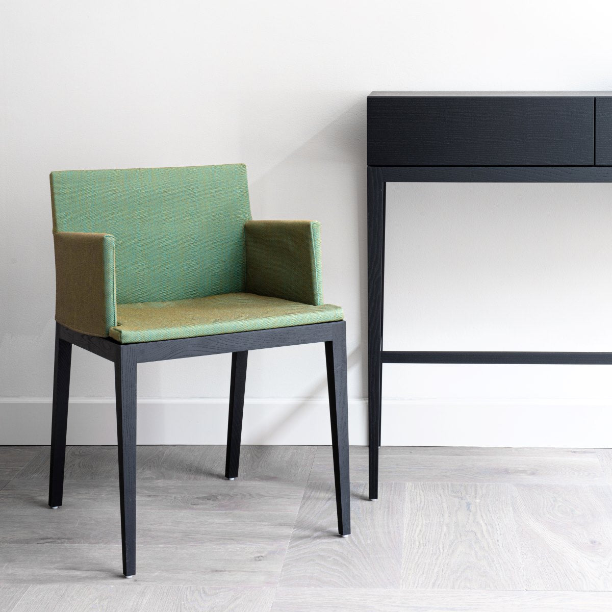 Stuhl BLOOM schwarz gebeizte Eiche mit grünem Bezug von Mint Furniture vor einer weißen Wand