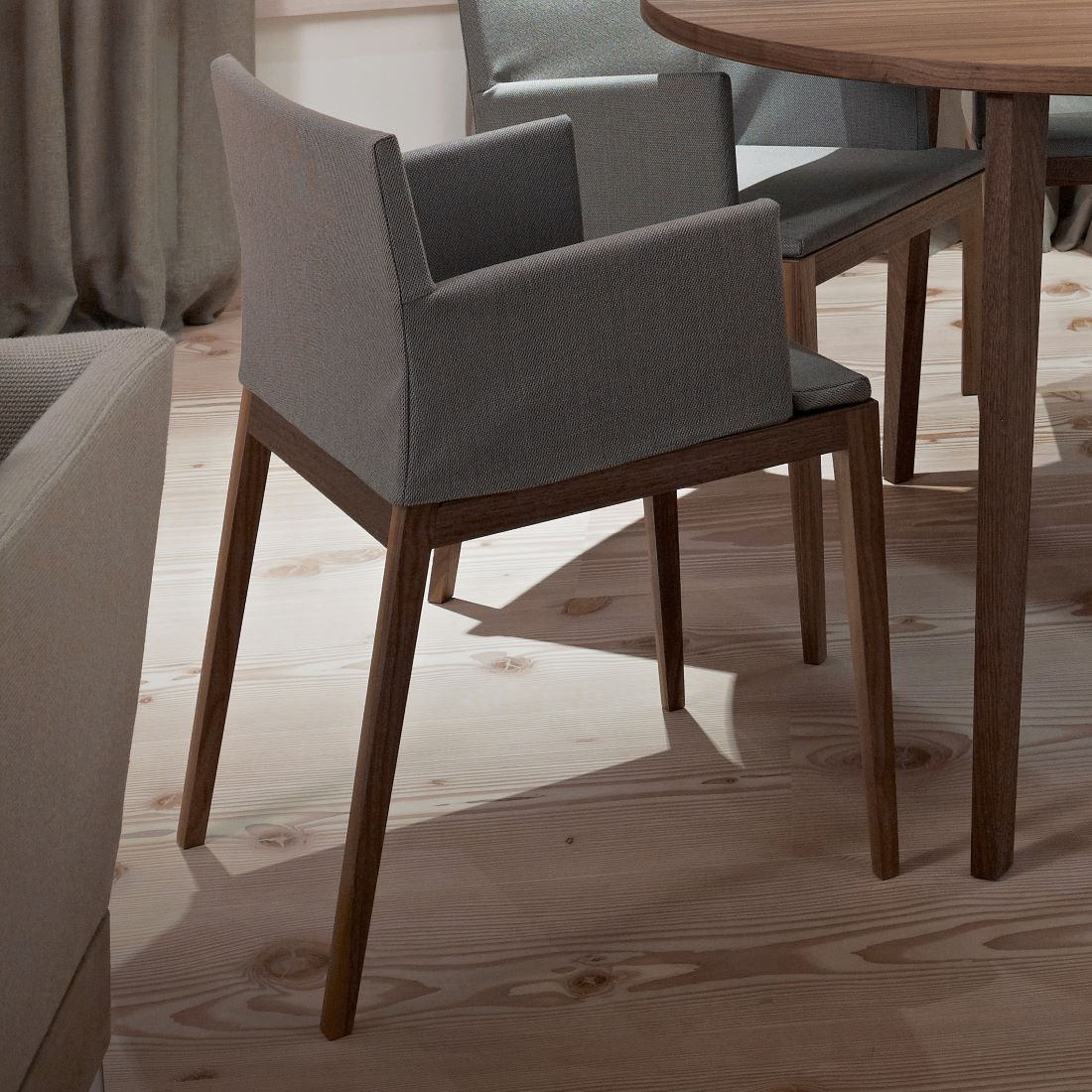Stuhl BLOOM Nussbaum mit grauem Bezug von Mint Furniture an einem runden Tisch