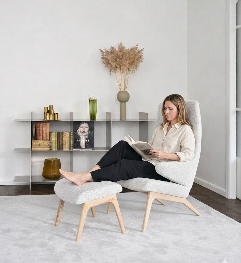 Sessel VOOG mit hellem Stoffbezug, auf dem eine lesende Frau sitzt; Hersteller: Oot-Oot (Tallinn), Bild: KI-generiert