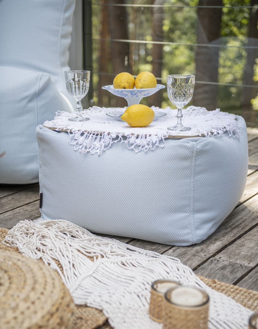 Sitzsack-Beistelltisch SOFT TABLE Hellgrau auf einer Holzterrasse mit Geschirr und Zitronen, Hersteller: Slowdown