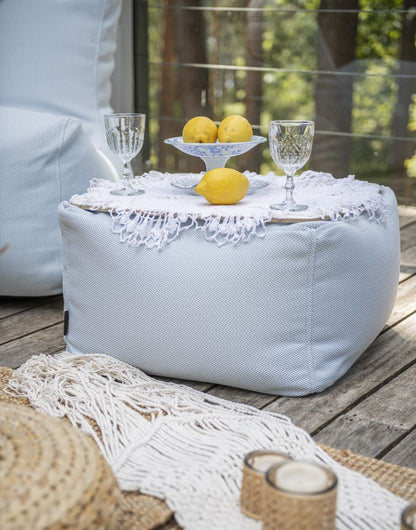 Sitzsack-Beistelltisch SOFT TABLE Hellgrau auf einer Holzterrasse mit Geschirr und Zitronen, Hersteller: Slowdown