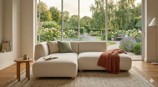 Sofa CAVA 250 mit Chaiselongue von Oot-Oot in einem Wohnzimmer mit Blick in den Garten. Bild: KI-generiert