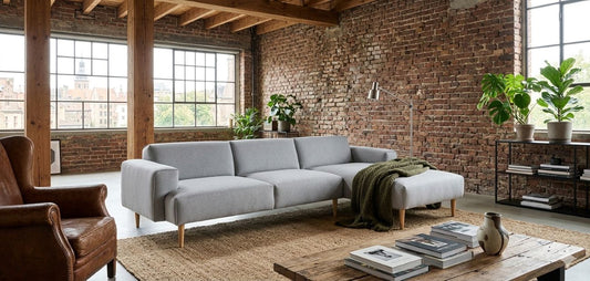 Sofa MOSS mit Chaiselongue von Oot-Oot in einem großzügigen Wohnzimmer mit rustikaler Backsteinwand, Bild: KI-generiert