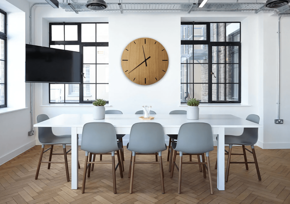 Die große Wanduhr TAIM an der Wand eines modern eingerichteten Besprechungsraums, Hersteller: Radis